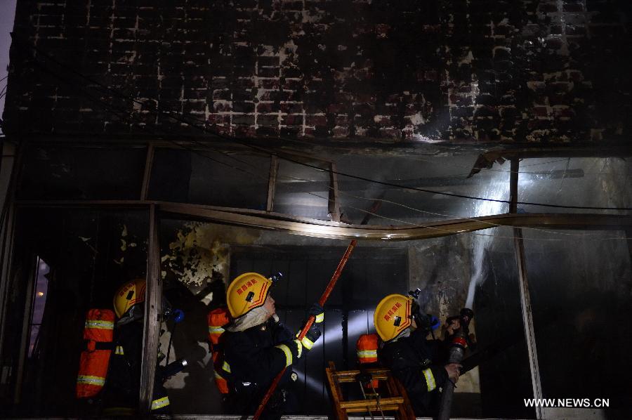 Firefighters extinguish fire at a residential building on the Honggu Road in Nanchang, capital of east China's Jiangxi Province, Jan. 6, 2013. A fire broke out on the first floor of the building on Sunday. No casualty is reported at present and the cause is still under investigation. (Xinhua/Zhou Mi)  