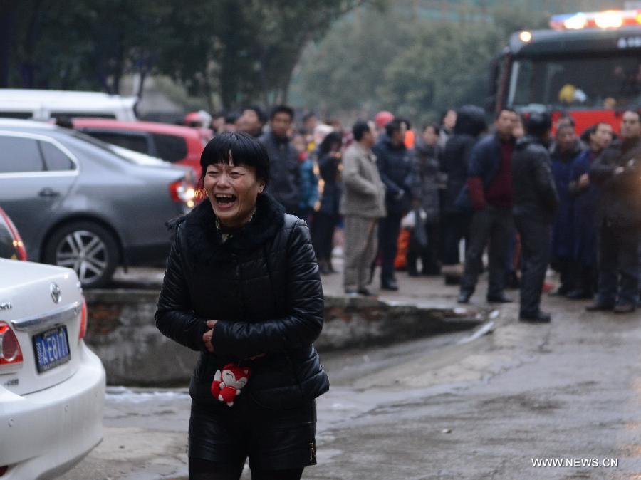 A resident reacts in front of a residential building on fire on the Honggu Road in Nanchang, capital of east China's Jiangxi Province, Jan. 6, 2013. A fire broke out on the first floor of the building on Sunday. No casualty is reported at present and the cause is still under investigation. (Xinhua/Zhou Mi)  