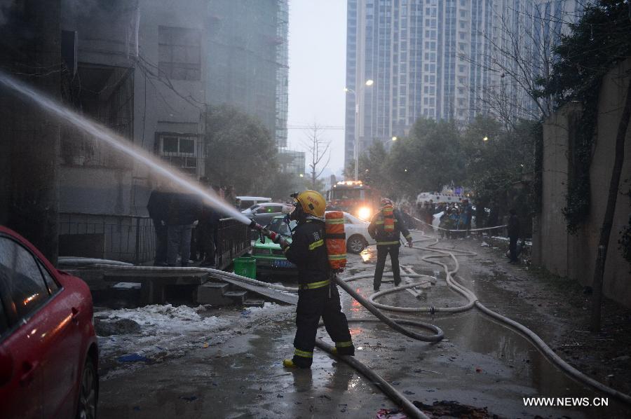 Firefighters extinguish fire at a residential building on the Honggu Road in Nanchang, capital of east China's Jiangxi Province, Jan. 6, 2013. A fire broke out on the first floor of the building on Sunday. No casualty is reported at present and the cause is still under investigation. (Xinhua/Zhou Mi) 