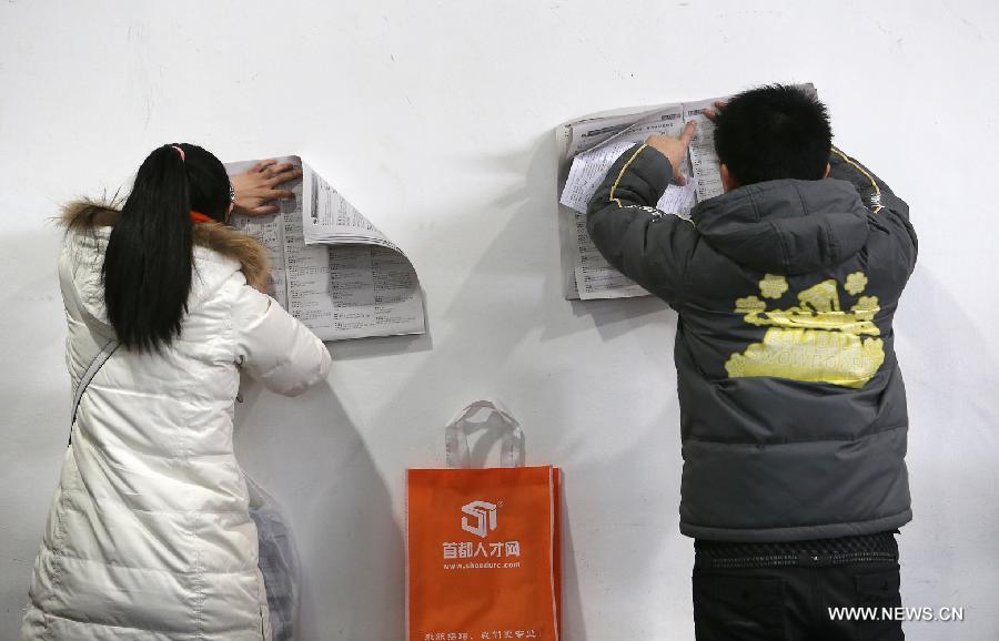 Job seekers search for job vacancy information at a job fair held at China International Exhibition Center in Beijing, China, Jan. 6, 2013. The job fair, held for postgraduates, provided 18,000 job vacancies and was expected to attract 40,000 job seekers. (Xinhua/Wan Xiang)