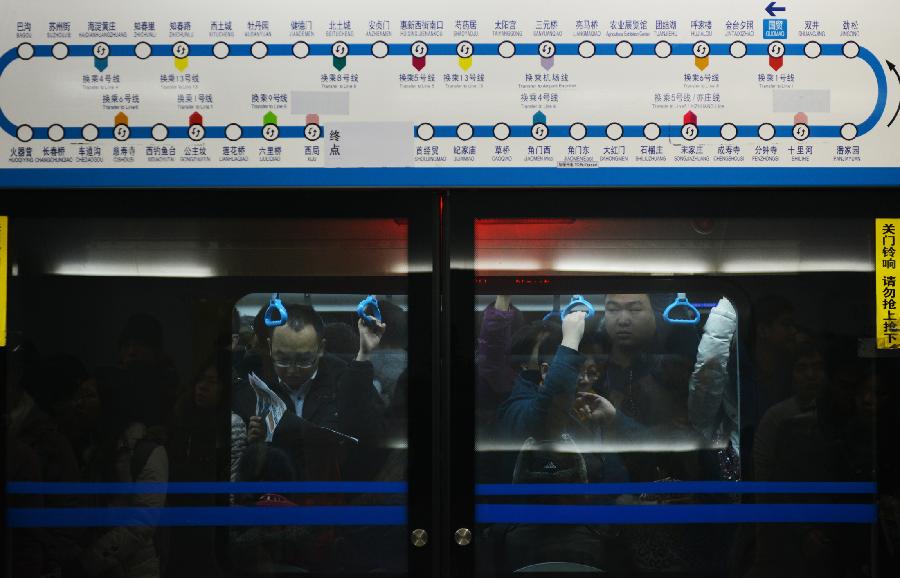 Commuters are pictured in a train of subway line 10 at the Guomao Station, in Beijing, capital of China, Jan. 7, 2013. Subway line 10 has reached a daily transportation of 1 million passengers on average, just a week after Phase II's opening that completed a loop for former line 10. Subway line 10 is expected to become the busiest line in Beijing. (Xinhua/Wang Quanchao)