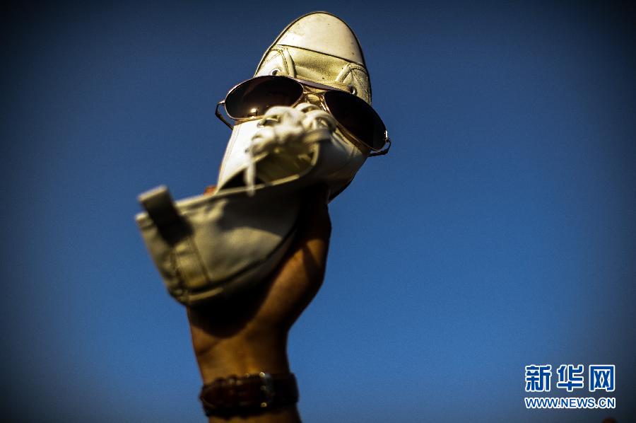 An Egyptian anti-Mubarak protester holds up his shoe at Cairo's Tahrir square on June 5, 2012. Thousands of Egyptians flocked to Cairo's iconic Tahrir square and other places on June 5, 2012 to protest the verdict handed down in ex-president Hosni Mubarak's case as well as presidential candidate Ahmed Shafiq, who they say is from the former regime. (Xinhua/Li Muzi) 