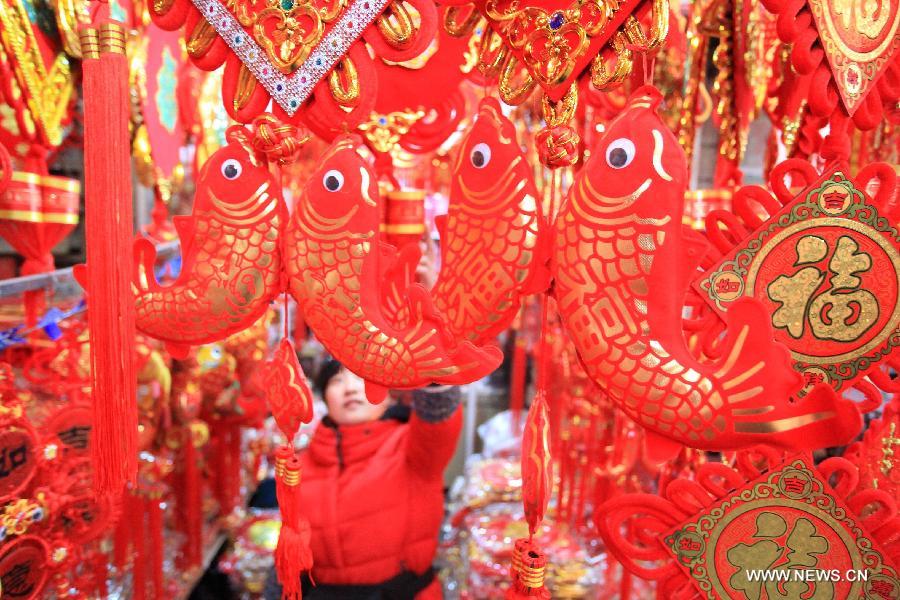 A customer selects ornaments to greet the upcoming Spring Festival, which falls on Feb. 10 this year, in Jimo City, east China's Shandong Province, Jan. 8, 2013. (Xinhua/Liang Xiaopeng)