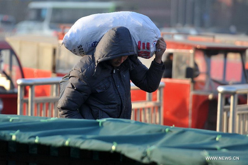 An immigrant worker walks into the Taiyuan Railway Station in Taiyuan, capital of north China's Shanxi Province, Jan. 8, 2013. As the Spring Festival draws near, immigrant workers have begun to go home for a family reunion, leading a travel peak at the railway station. The Spring Festival, the most important occasion for a family reunion for the Chinese people, falls on the first day of the first month of the traditional Chinese lunar calendar, or Feb. 10 this year. (Xinhua/Yan Yan) 