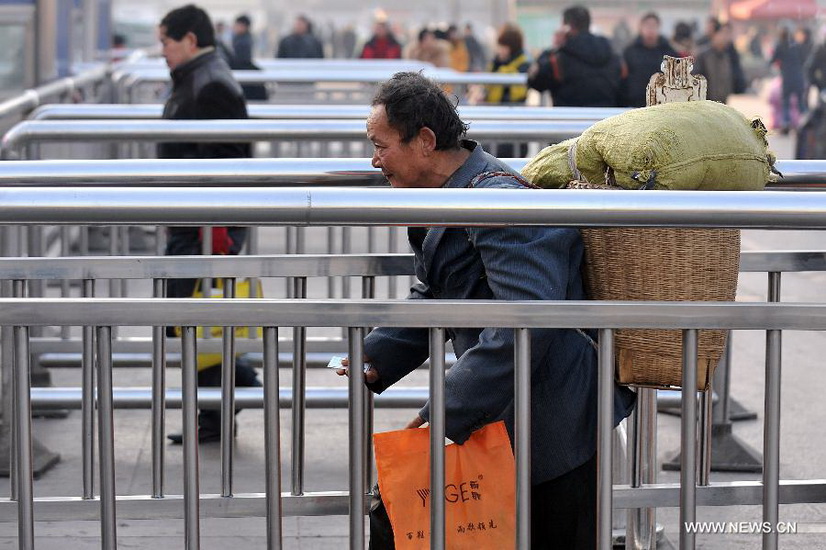 An immigrant worker walks into the Taiyuan Railway Station in Taiyuan, capital of north China's Shanxi Province, Jan. 8, 2013. As the Spring Festival draws near, immigrant workers have begun to go home for a family reunion, leading a travel peak at the railway station. The Spring Festival, the most important occasion for a family reunion for the Chinese people, falls on the first day of the first month of the traditional Chinese lunar calendar, or Feb. 10 this year. (Xinhua/Yan Yan) 