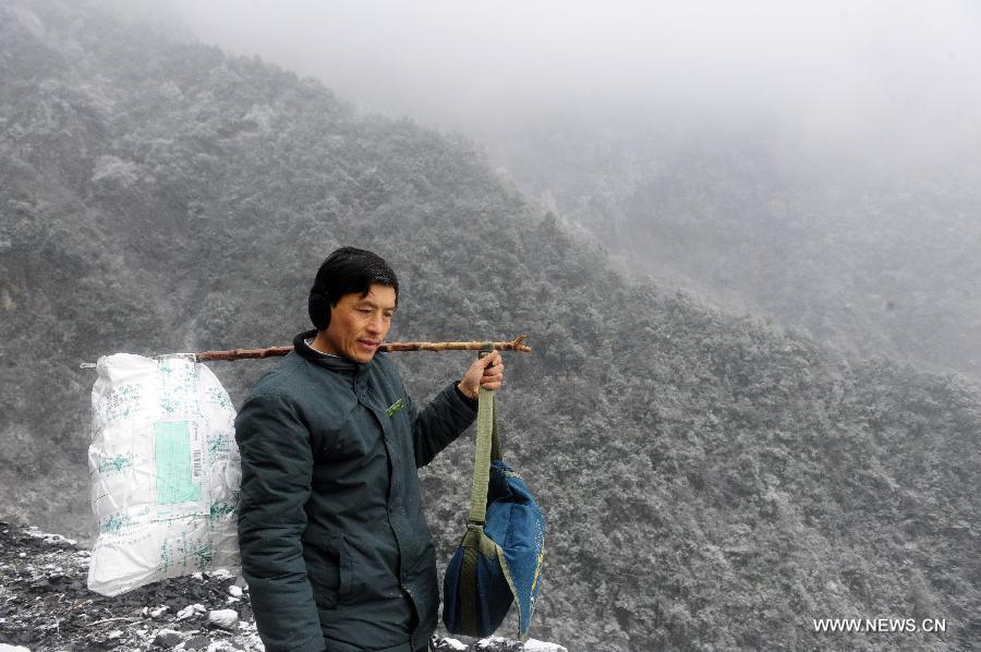 Postman Zhang Meichong is on his way to send letters at a mountainous village in Enshi, central China's Hubei Province, Dec. 23, 2012. Equipped with a stick and two bags, Zhang Meichong, a village postman, has been working in the mountainous area for 15 years and traveled a distance about 180,000 kilometers these years. (Xinhua/Hao Tongqian)  