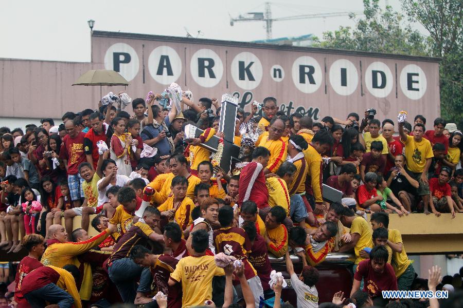 Devotees try to touch and kiss the life-size statue of the Black Nazarene during the annual feast of the Black Nazarene in Manila, the Philippines, Jan. 9, 2013. The Black Nazarene, a life-size wooden statue of Jesus Christ carved in Mexico and brought to the Philippines in the 17th century, is believed to have healing powers in this country. Authorities said about 500,000 people participated in the procession that started in Manila's Rizal Park. (Xinhua/Rouelle Umali)