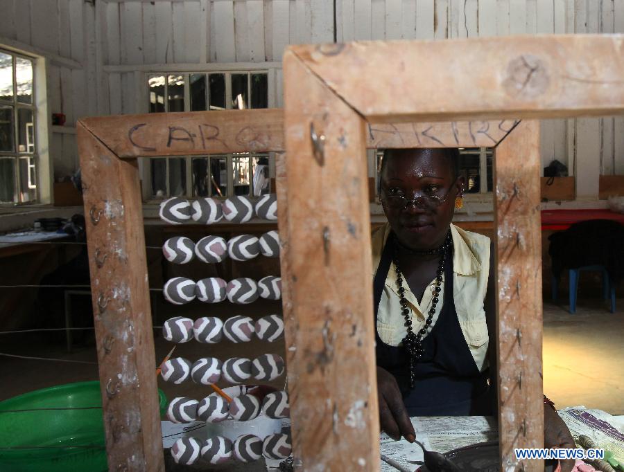 A woman paints on ceramic beads at the Kazuri factory in Nairobi, Kenya, Jan. 8, 2013. Kazuri, which means "small and beautiful" in Swahili, began in 1975 as a workshop experimenting on making handmade beads. The factory employs over 340 women, mostly single mothers. Its handmade and hand-painted ceramic jewellery and pottery products have been exported to over 30 countries and regions worldwide. (Xinhua/Meng Chenguang)