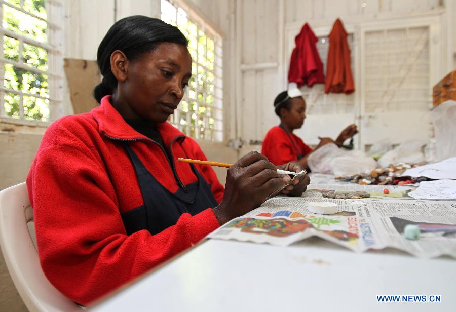 Two women paint on ceramic beads at the Kazuri factory in Nairobi, Kenya, Jan. 8, 2013. Kazuri, which means "small and beautiful" in Swahili, began in 1975 as a workshop experimenting on making handmade beads. The factory employs over 340 women, mostly single mothers. Its handmade and hand-painted ceramic jewellery and pottery products have been exported to over 30 countries and regions worldwide. (Xinhua/Meng Chenguang)