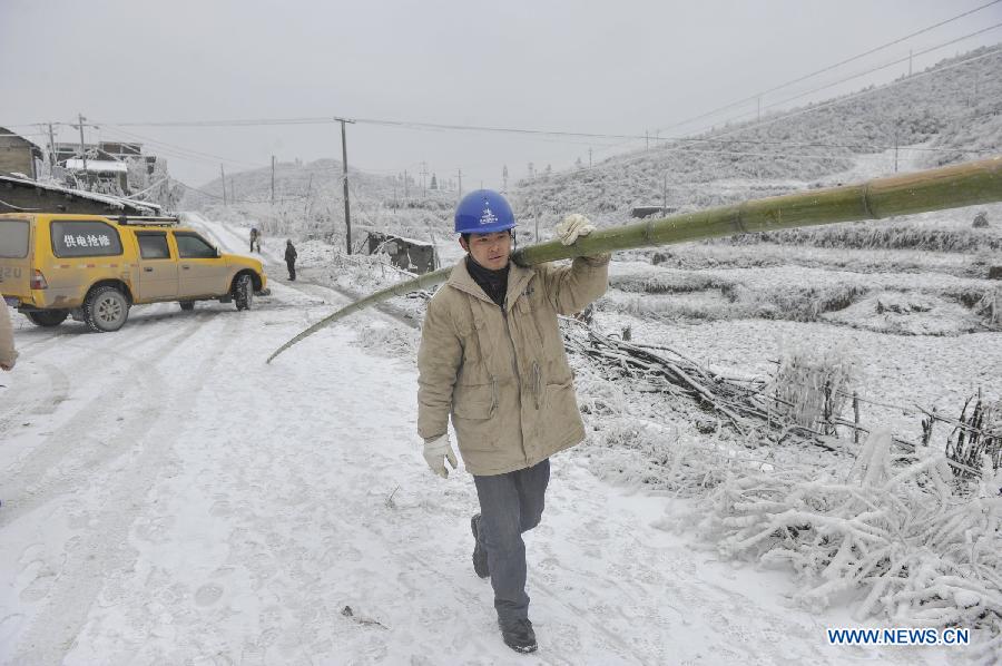 A worker carries a bamboo stick to clean the ice on the power line in Yongsha Village of Shuangliu Township in Kaiyang County, southwest China's Guiyang, Jan. 10, 2013. Local power grid company sent workers to clean power lines which couldn't melt the ice with automatic equipment. (Xinhua/Ou Dongqu) 