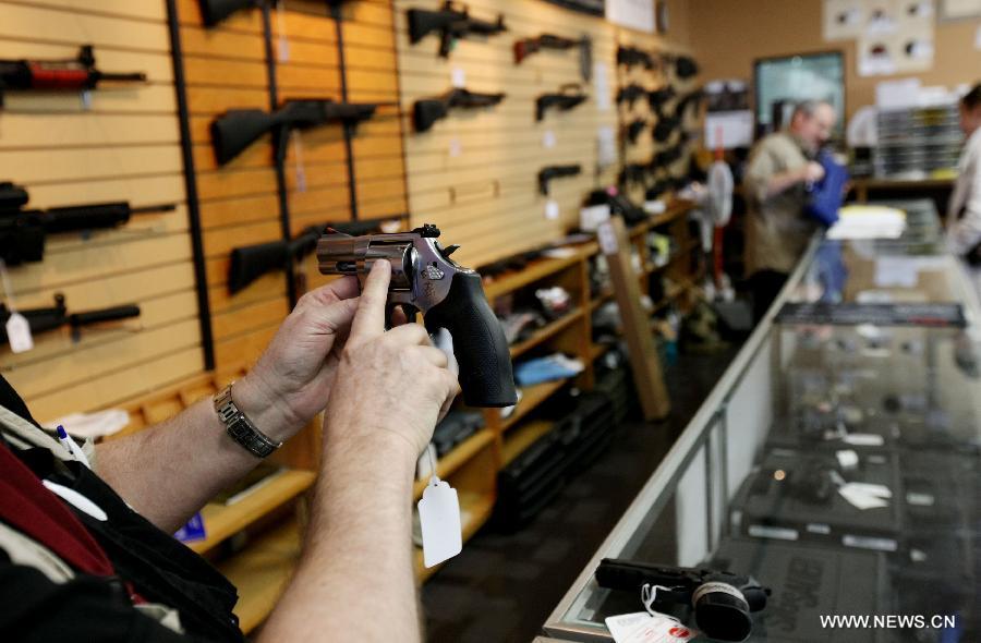 Shop assistant explains the functions of a revolving pistol at a gun shop in Chantilly, Virginia, the United States, on Jan. 10, 2013. U.S. Vice President Joe Biden said on Thursday he will present proposals of the White House gun-control task force to President Barack Obama by next Tuesday. (Xinhua/Fang Zhe) 