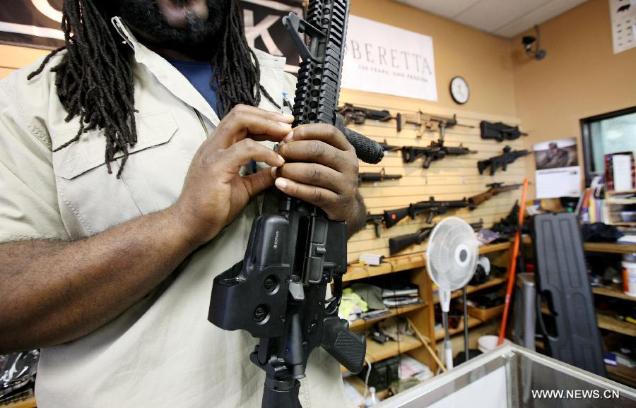 Shop assistant explains the function of a rifle at a gun shop in Chantilly, Virginia, the United States, on Jan. 10, 2013. U.S. Vice President Joe Biden said on Thursday he will present proposals of the White House gun-control task force to President Barack Obama by next Tuesday. (Xinhua/Fang Zhe) 