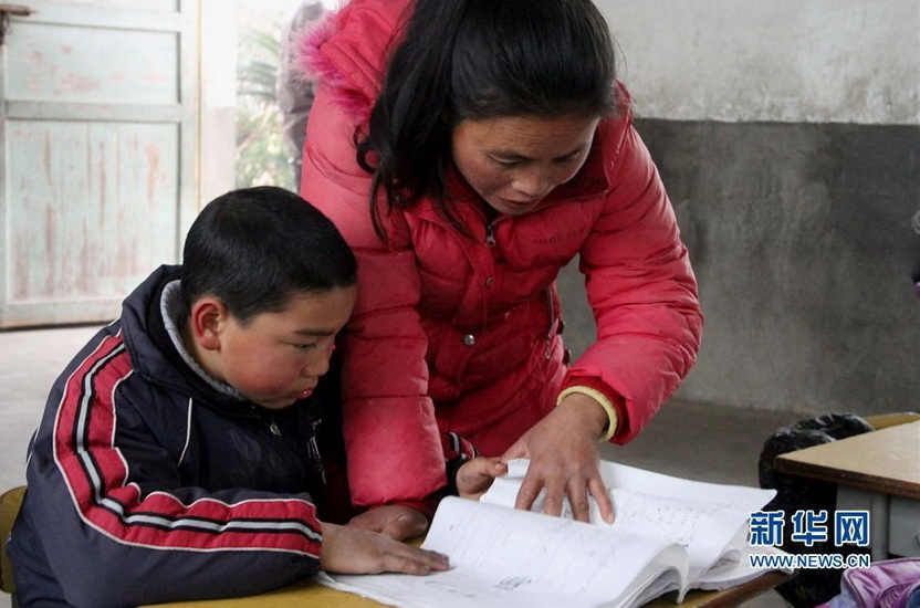 Wu Sulan accompanies his son reading textbook on Jan.8, 2013.  (Xinhua/Huchao)