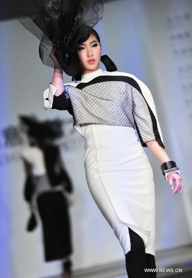 A model presents outfits at a creative fashion design competition held at Tianjin Polytechnic University in north China's Tianjin, Jan. 11, 2013. The competition held its final here Friday. (Xinhua/Zuo Shan)