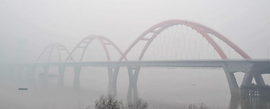 Xiangjiang Bridge is seen amid dense fog in Changsha City, capital of central China's Hunan Province, Jan. 12, 2013. A fog hit Changsha on Saturday. (Xinhua/Long Hongtao) 