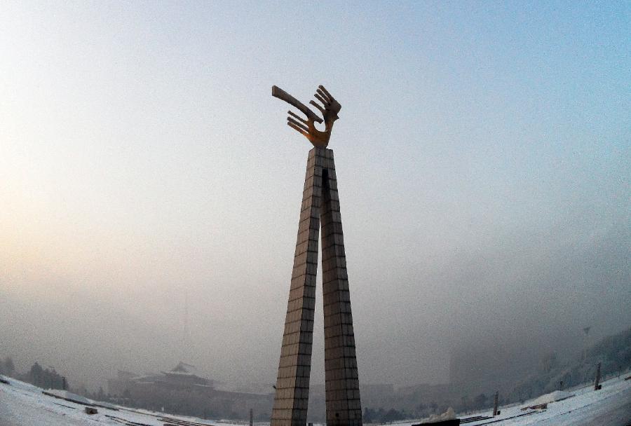 Buildings around the Wenhua Square are shrouded in the fog in Changchun, capital of northeast China's Jilin Province, Jan. 13, 2013. Heavy fog hit Changchun on Sunday. (Xinhua/Lin Hong) 