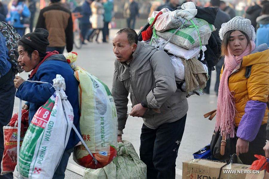 Immigrant workers walk into the Taiyuan Railway Station in Taiyuan, capital of north China's Shanxi Province, Jan. 8, 2013. As the Spring Festival draws near, immigrant workers have begun to go home for a family reunion, leading a travel peak at the railway station. The Spring Festival, the most important occasion for a family reunion for the Chinese people, falls on the first day of the first month of the traditional Chinese lunar calendar, or Feb. 10 this year. (Xinhua/Yan Yan)