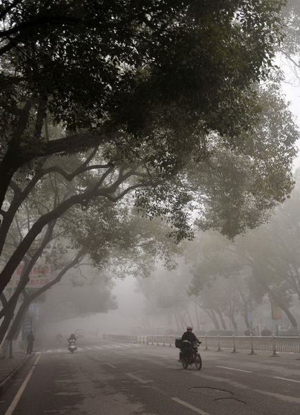 Citizens ride on the fog-shrouded Chongxin Road in Guilin, southwest China's Guangxi Zhuang Autonomous Region, Jan. 13, 2013. Dense fog on Sunday hit China's east and central regions from the northeast to the south, causing serious air pollution. (Xinhua/Lu Bo'an) 