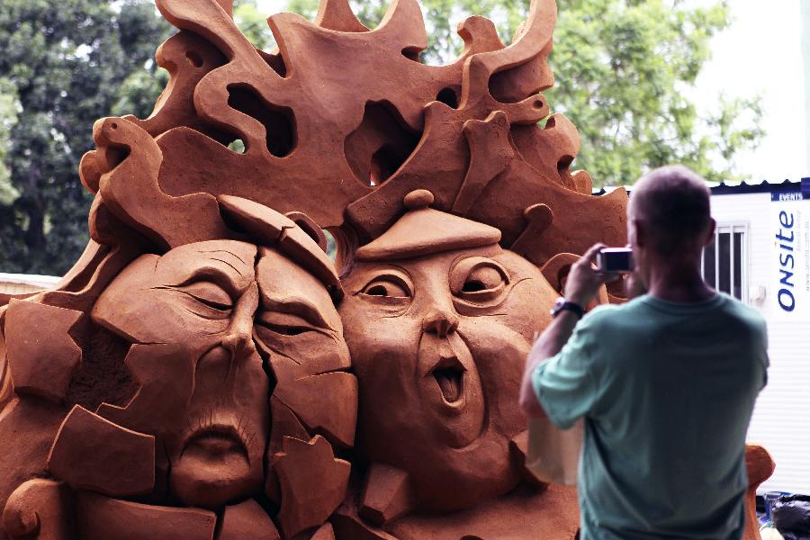 A visitor takes photo of champion work of the 2nd Hawkesbury International Sand Sculpture Contest in Windsor, Australia, on Jan. 13, 2013. The 2nd Hawkesbury International Sand Sculpture Contest was held here on Sunday. A total of 14 sand sculpture works for the contest will be on exhibit in 15 days.(Xinhua/Jin Linpeng) 