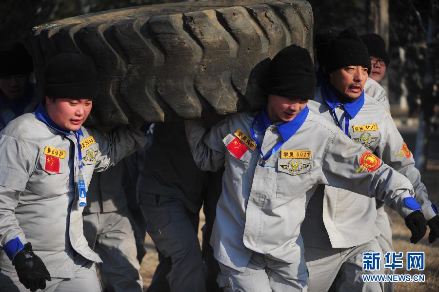 Trainees carry tires to train physical strength on Jan. 2, 2013. (Xinhua/ Liu Changlong)