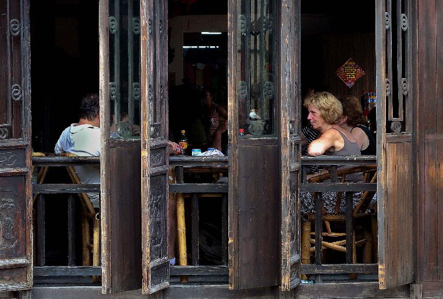 Visitors rest in a tea house of Wuzhen ancient town in Tongxiang City, east China's Zhejiang Province, July 18, 2009. (Xinhua/Wang Song)