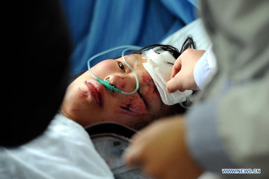 A woman injured in an accident on an express way receives treatment in Xifeng county, southwest China's Guizhou Province, Jan. 13, 2013. Five people died and 19 others were injured after a coach collided with a guardrail and rolled over around 5 a.m. Sunday. (Xinhua) 