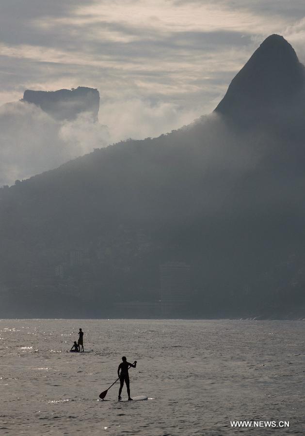 People stand on surfboards at Ipanema Beach in Rio de Janeiro, Brazil, Jan. 13, 2013.(Xinhua/Weng Xinyang) 