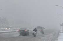 Vehicles move in the fog on a street in Changchun