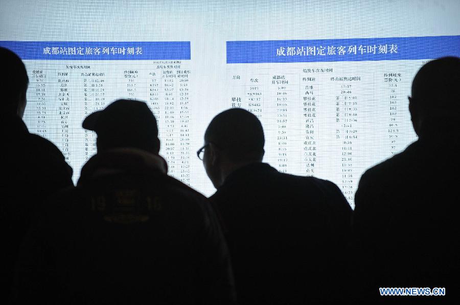Passengers check train schedule in a railway station in Chengdu, capital of southwest China's Sichuan Province, Jan. 14, 2013. The peak of Spring Festival travel train tickets purchase started from Jan. 13, 2013 in Chengdu. (Xinhua/Xue Yubin)