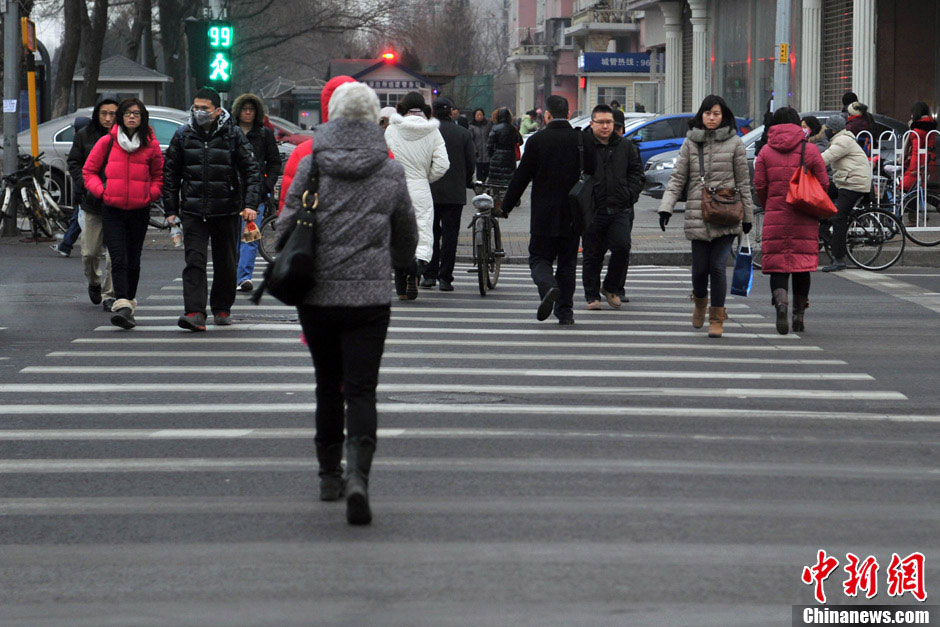 Light snow falls in some areas in Beijing on Tuesday morning, which is expected to ease the air pollution caused by days-long dense fog. The air quality will be improved further by wind due to a cold front that will affect north and east China from Jan. 16, 2012, the National Meteorological Center forecasts. (Photo/Chinanews.com)