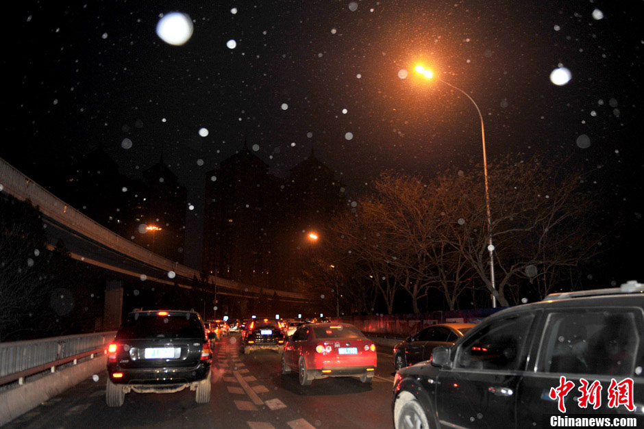 Light snow falls in some areas in Beijing on Tuesday morning, which is expected to ease the air pollution caused by days-long dense fog. The air quality will be improved further by wind due to a cold front that will affect north and east China from Jan. 16, 2012, the National Meteorological Center forecasts. (Photo/Chinanews.com)