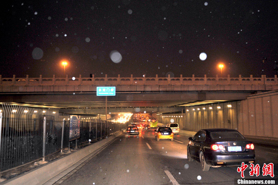 Light snow falls in some areas in Beijing on Tuesday morning, which is expected to ease the air pollution caused by days-long dense fog. The air quality will be improved further by wind due to a cold front that will affect north and east China from Jan. 16, 2012, the National Meteorological Center forecasts. (Photo/Chinanews.com)