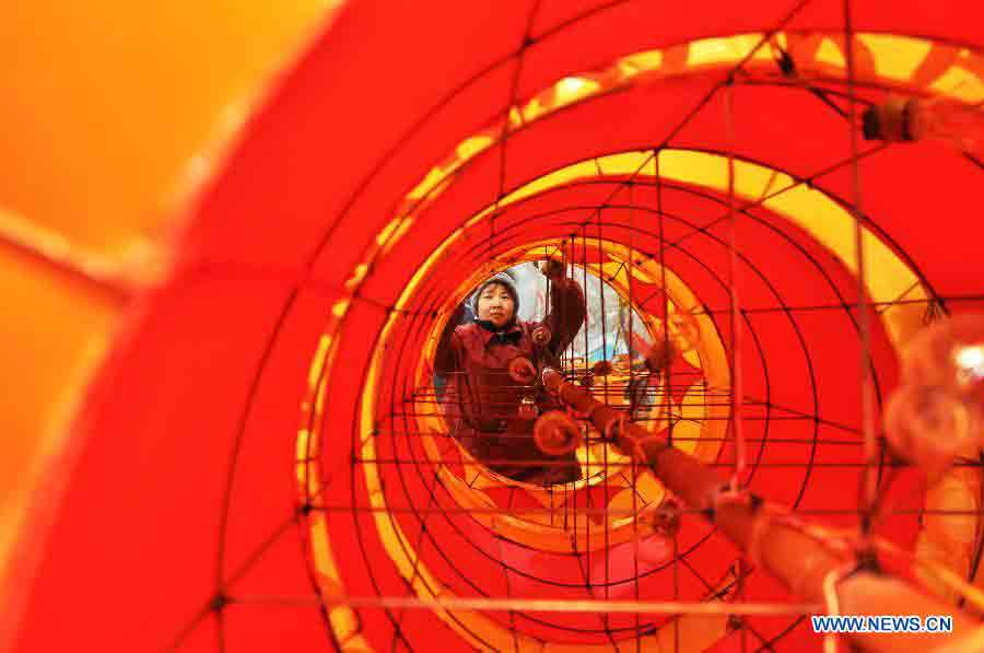 A worker decorates a lantern in a lantern factory in Zhoucun District of Zibo, east China's Shandong Province, Jan. 14, 2013. As traditional Chinese Spring Festival is coming, lantern factories here have come to a busy production season. (Xinhua/Dong Naide)