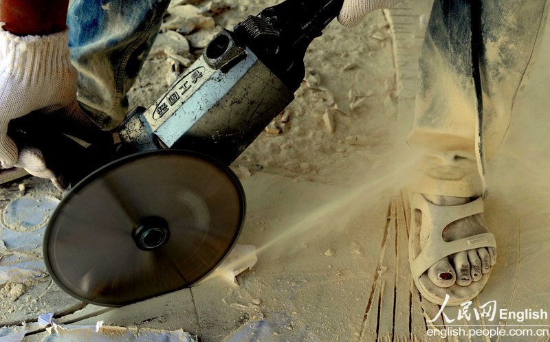 A worker's toes are eroded by bioaccumulation contained in the industrial dust, in a stone material factory in Aksu, Xinjiang, Oct. 25, 2012. (Photo/People's Daily Online)