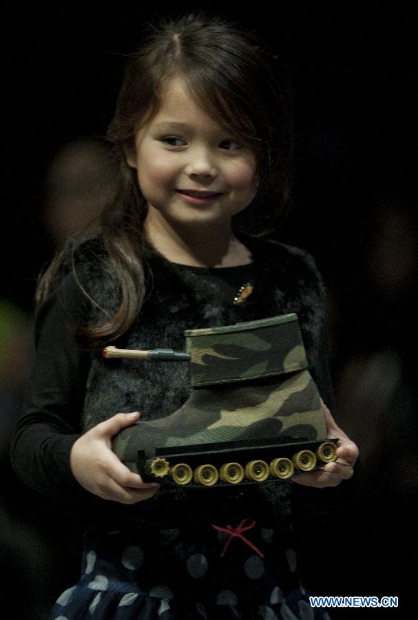 A young model presents an entry of the 13th Hong Kong Footwear Design Competition during the awarding ceremony of the event in south China's Hong Kong, Jan. 15, 2013. The ceremony is held on the second day of the Hong Kong Fashion Week for Fall/Winter, which lasts from Jan. 14 to Jan. 17 at Hong Kong Convention and Exhibition Centre. (Xinhua/Lui Siu Wai) 