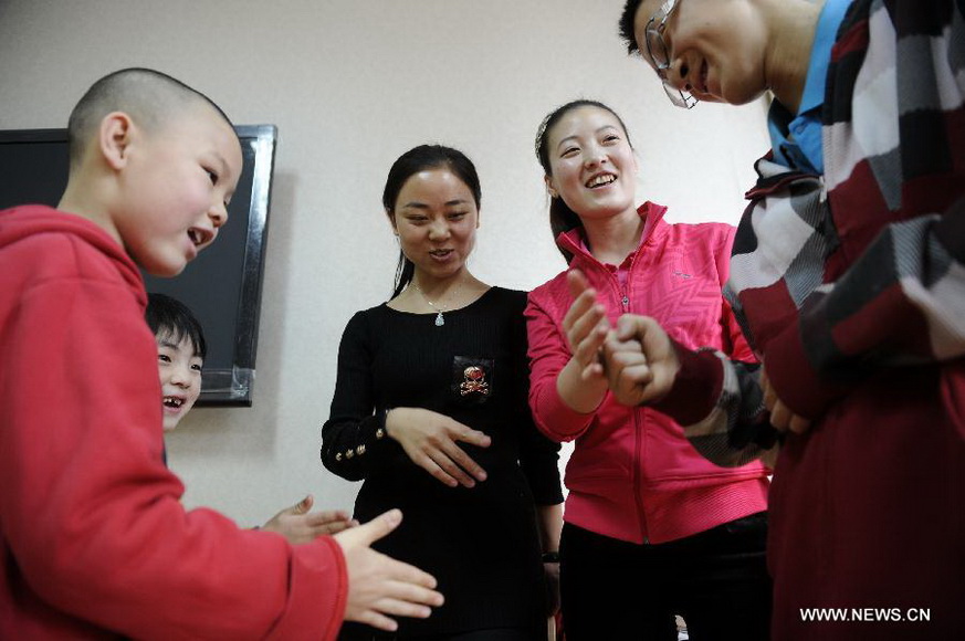 Teachers plays with children in Ningxia Children Welfare Center in Yinchuan, capital of northwest China's Ningxia Hui Autonomous Region, Jan. 15, 2013. The welfare center recently moved to a new home, providing a more comfortable living environment to more than 300 orphans. (Xinhua/Li Ran)