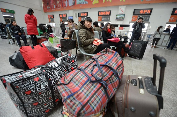 Passengers wait for their trains at Hangzhou railway station in East China's Zhejiang province, on Jan 15, 2013. Hangzhou railway station is expected to transport around 34 million people during the approaching Spring Festival travel rush, which is still more than 10 days away.(Photo/Xinhua)