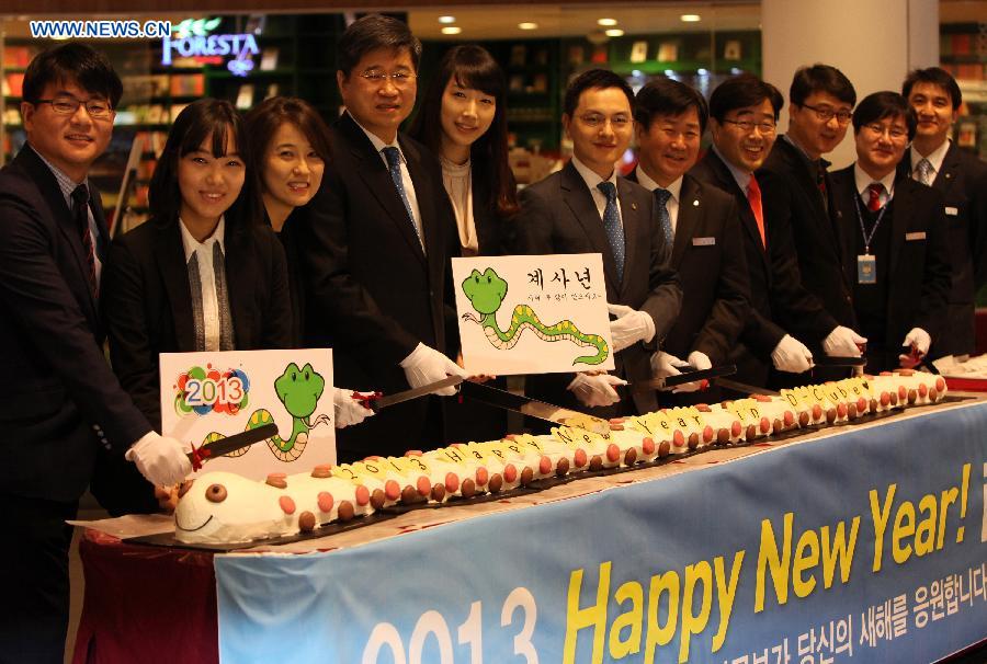 Staff pose for photos with a 3-meter snake cake during the new year celebration at a department store in Seoul, South Korea, Jan. 1, 2013. The year of 2013 is the Year of Snake. (Xinhua/Park Jin hee) 