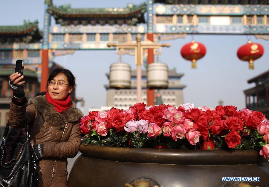A tourist takes photos on the Qianmen Street in Beijing, capital of China, Jan. 16, 2013. Beijingers on Wednesday saw their first sunshine in seven days, with a cold front dispersing the lingering smog in the city. (Xinhua/Li Fangyu)