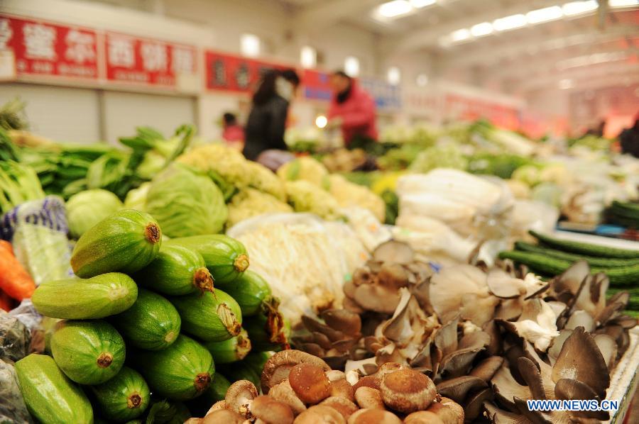 A local resident selects vegetables at a market on Tabei Road in Shijiazhuang, capital of north China's Hebei Province, Jan. 16, 2013. According to the Ministry of Commerce, the price of agricultural products in 36 large-and-medium-sized cities across the nation continued to rise from Jan. 7, 2013 to Jan. 13, 2013, a continuous rising in 11 consecutive weeks. (Xinhua/Zhu Xudong)