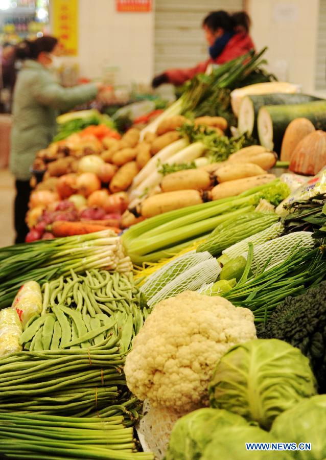 A local resident selects vegetables at a market on Tabei Road in Shijiazhuang, capital of north China's Hebei Province, Jan. 16, 2013. According to the Ministry of Commerce, the price of agricultural products in 36 large-and-medium-sized cities across the nation continued to rise from Jan. 7, 2013 to Jan. 13, 2013, a continuous rising in 11 consecutive weeks. (Xinhua/Zhu Xudong)