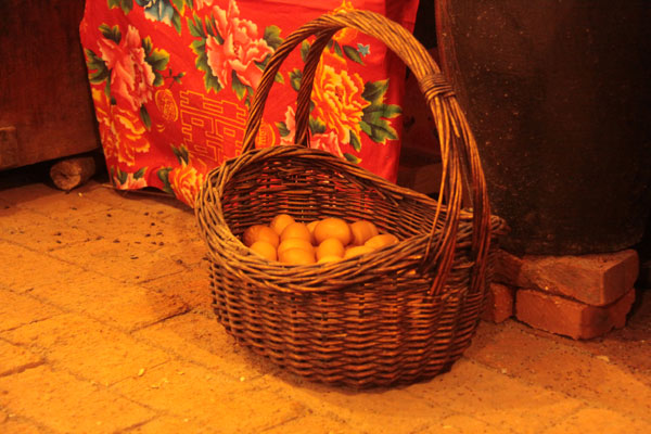 This photo on December 20, 2012, shows a basket of eggs in a house made of snow, which contains a collection of local rural furniture, daily articles and hunting products in Harbin, northeast China's Heilongjiang Province. (CRIENGLISH.com)