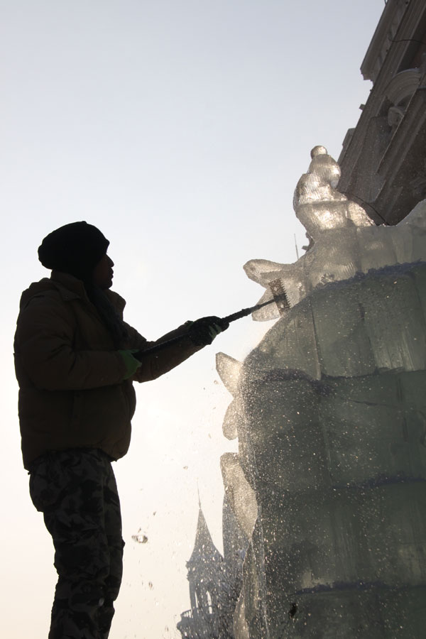 An ice sculptor carves a block of ice on Central Street in Harbin, northeast China's Heilongjiang Province, on December 18, 2012. (CRIENGLISH.com)