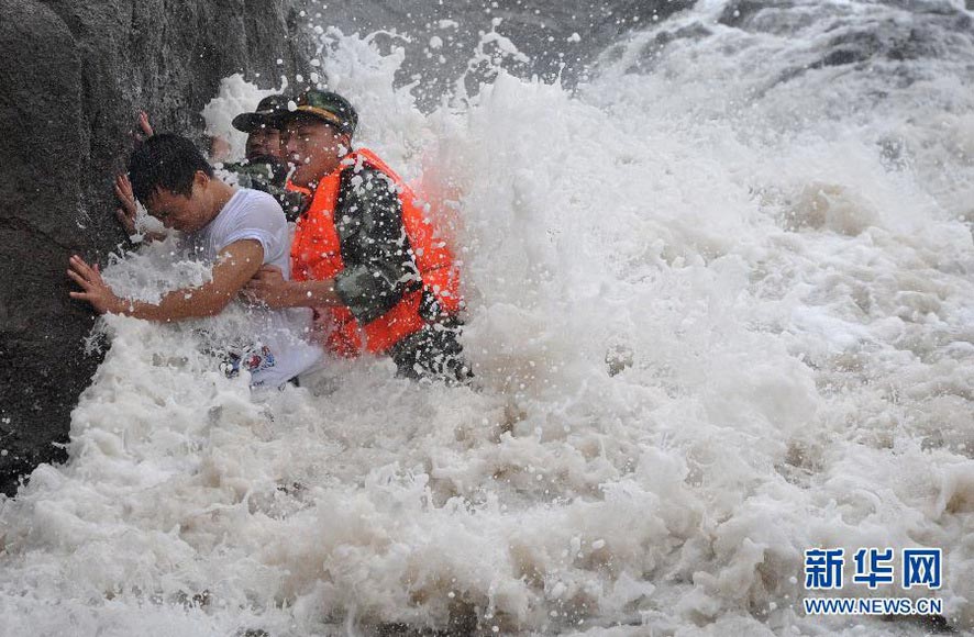 Border solider help the tourists leave to the dangerous area in Taizhou on Aug. 2, 2012. Affected by Typhoon Saola, Tauzhou was hit by heavy rainstorm. (Xinhua/Xia Ce)