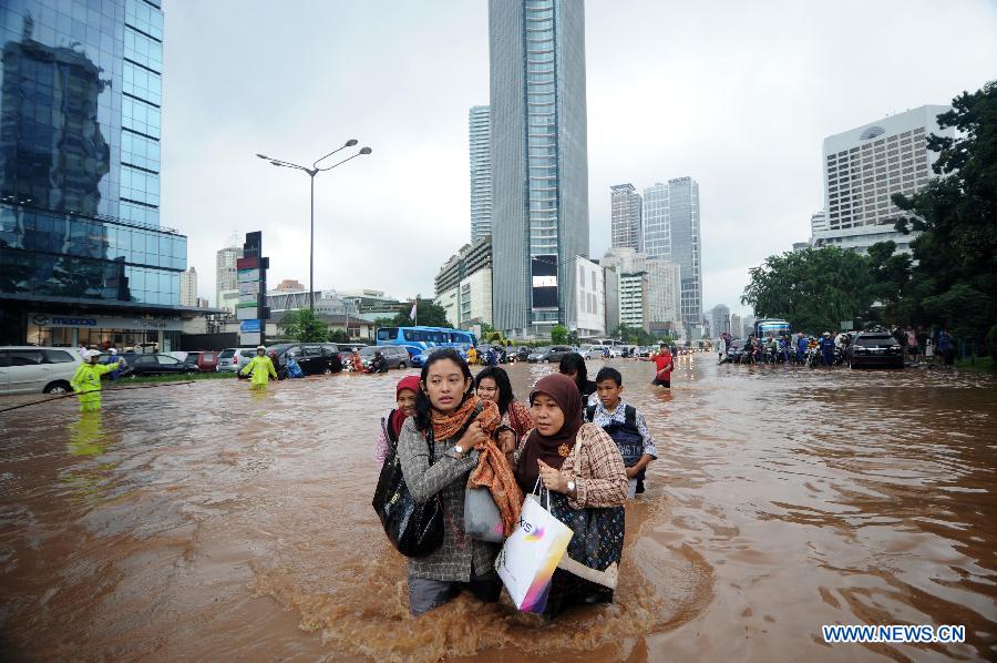 People wade through flood waters in Jakarta, Indonesia, Jan. 17, 2013. The Indonesian capital city of Jakarta was paralyzed by flood on Thursday following a massive downpour since Wednesday night, with its main roads inundated, public transport disrupted and operation of government offices and private sector coming to a standstill. (Xinhua/Veri Sanovri)