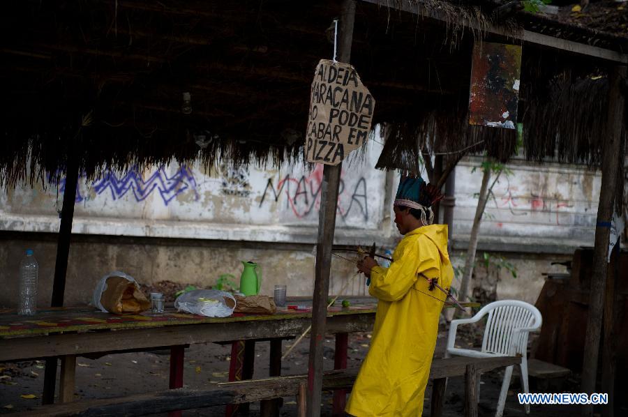 An Indigenous man sharpens an arrow at the old Indian Museum in Rio de Janeiro,Brazil, Jan. 16, 2013. The government of Rio de Janeiro plans to tear down an old Indian museum beside Maracana Stadium to build parking lot and shopping center here for the upcoming Brazil 2014 FIFA World Cup. The plan met with protest from the indigenous groups. Now Indians from 17 tribes around Brazil settle down in the old building, appealing for the protection of the century-old museum, the oldest Indian museum in Latin America. They hope the government could help renovate it and make part of it a college for indigenous Indians. (Xinhua/Weng Xinyang) 