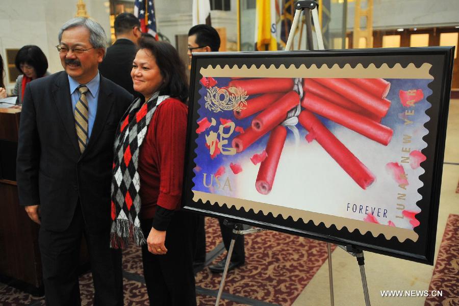 Edwin Lee (L), mayor of San Francisco, poses with a citizen in front of the "Snake Stamp", stamp featuring the Chinese Lunar New Year of the Snake, at the launching ceremony in San Francisco, the United States, on Jan. 16, 2013. (Xinhua/Liu Yilin) 