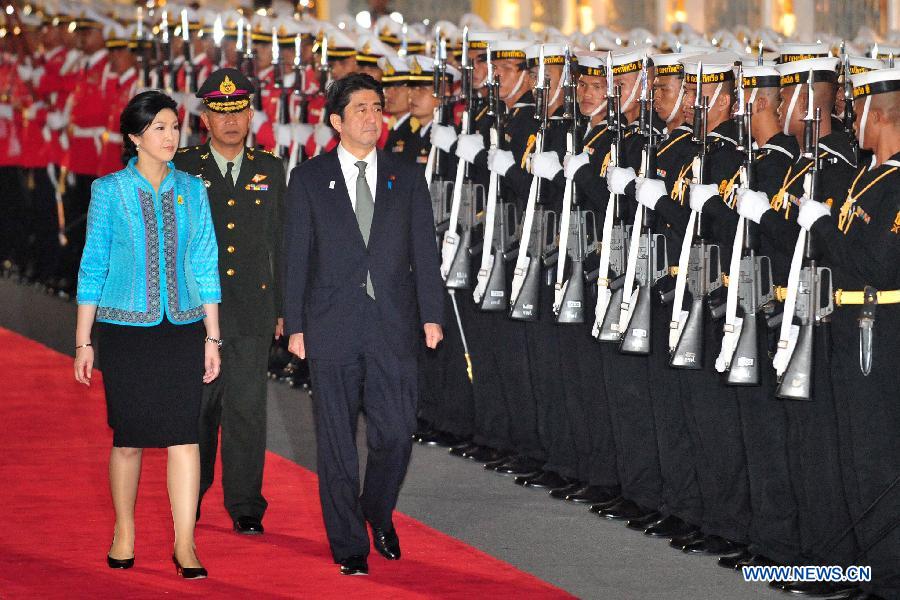 Thai Prime Minister Yingluck Shinawatra (1st L) and Japanese Prime Minister Shinzo Abe (C) inspect the guards of honor during a welcoming ceremony held at the Government House in Bangkok, capital of Thailand, Jan. 17, 2013. Shinzo Abe arrived in Bangkok on Thursday for a two-day official visit to Thailand. (Xinhua/Rachen Sageamsak) 