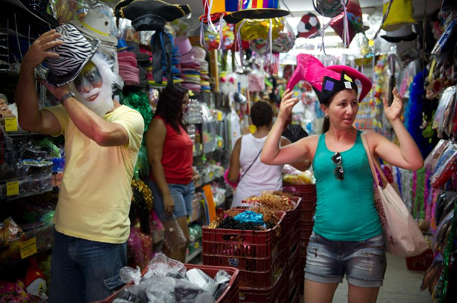 A couple try on carnival accessories in a store in central Rio de Janeiro, Brazil, Jan. 18, 2013. Carnival-related products sell like hot cakes in Brazil, three weeks away from the annual Rio de Janeiro Carnival. (Xinhua/Weng Xinyang) 