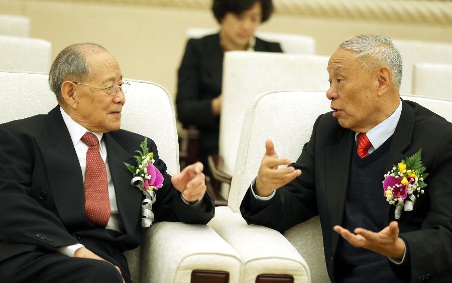 Explosions expert Zheng Zhemin (L) talks with radar engineer Wang Xiaomo during the awarding ceremony of the State Scientific and Technological Award in Beijing, capital of China, Jan. 18, 2013. Zheng and Wang won China's top science award on Friday. (Xinhua/Ju Peng) 